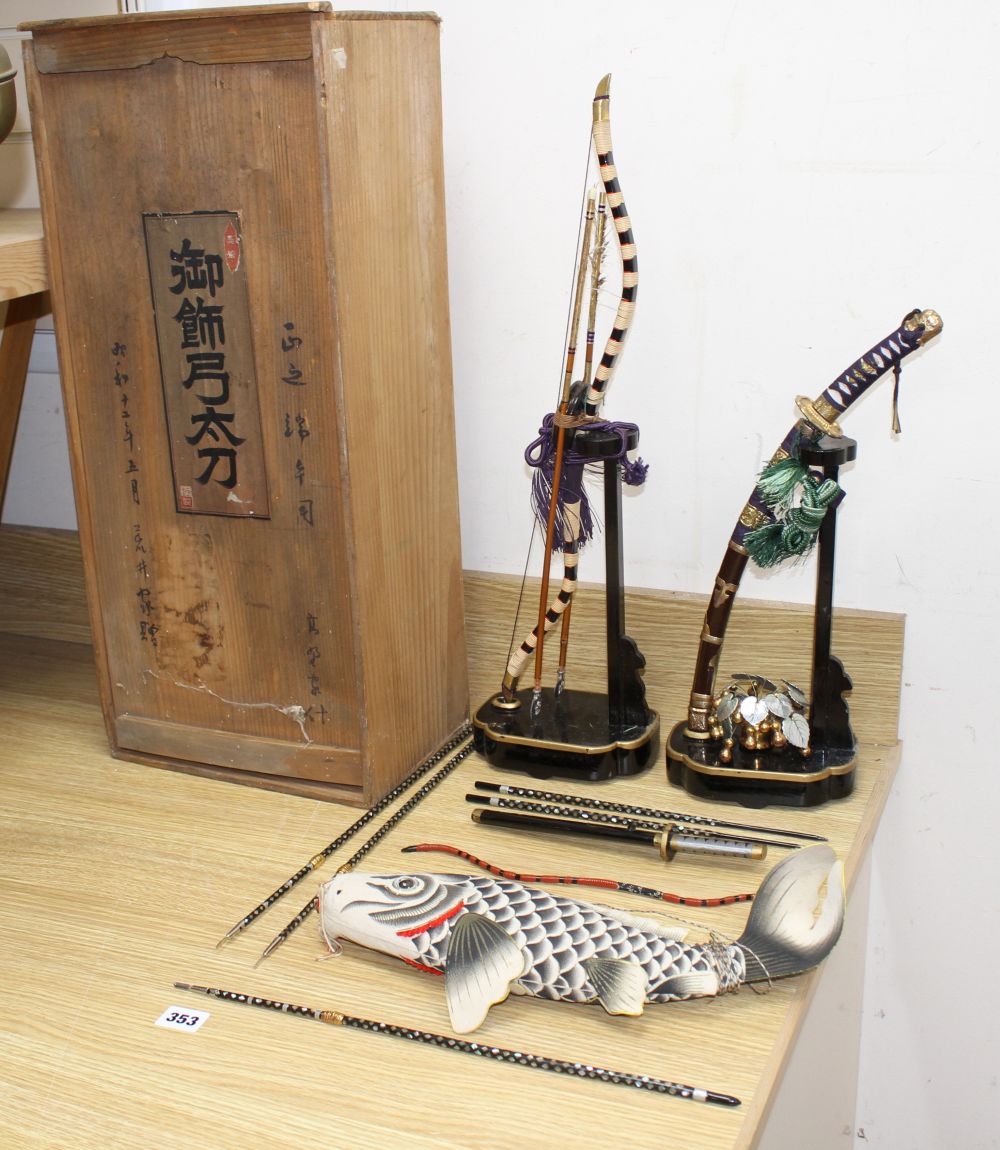 A Japanese late Meiji period set of lacquered model weapons on display stands, comprising archers bow, samurai sword and other weapons